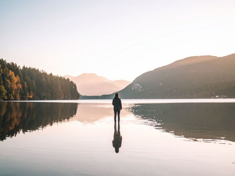 Person Standing in Calm Lake with Mountain View holistic approach