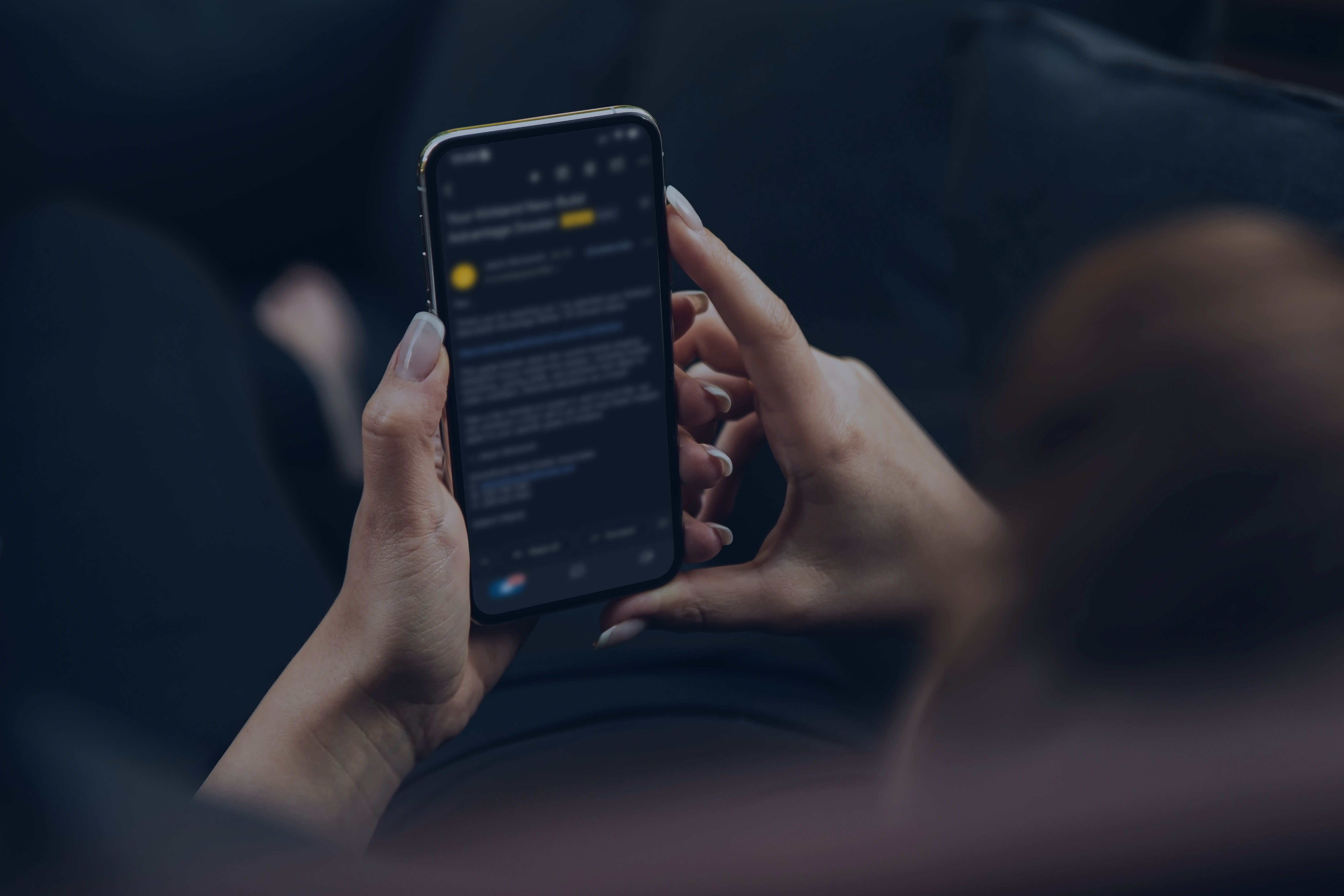 A woman holding a smartphone while viewing an email message on the screen, representing receiving important information digitally.