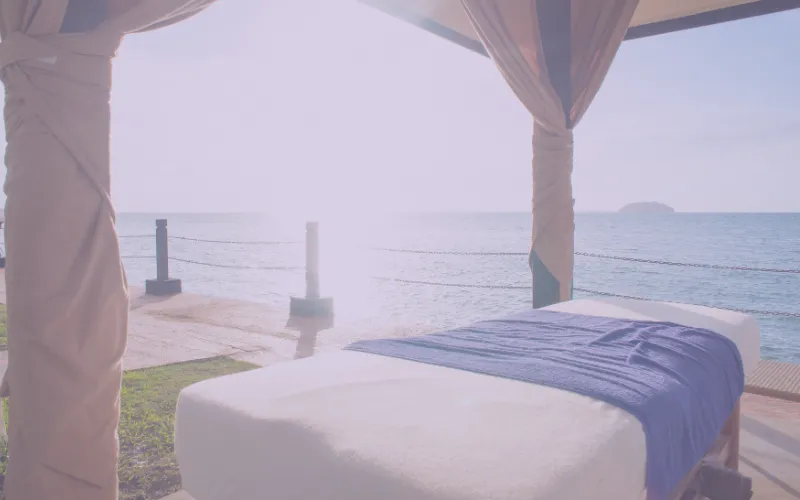 Woman receiving a relaxing massage with gentle hands on her forehead, emphasizing spa services like Post Op Massage and Swedish Massage offered by Spa Mobile.