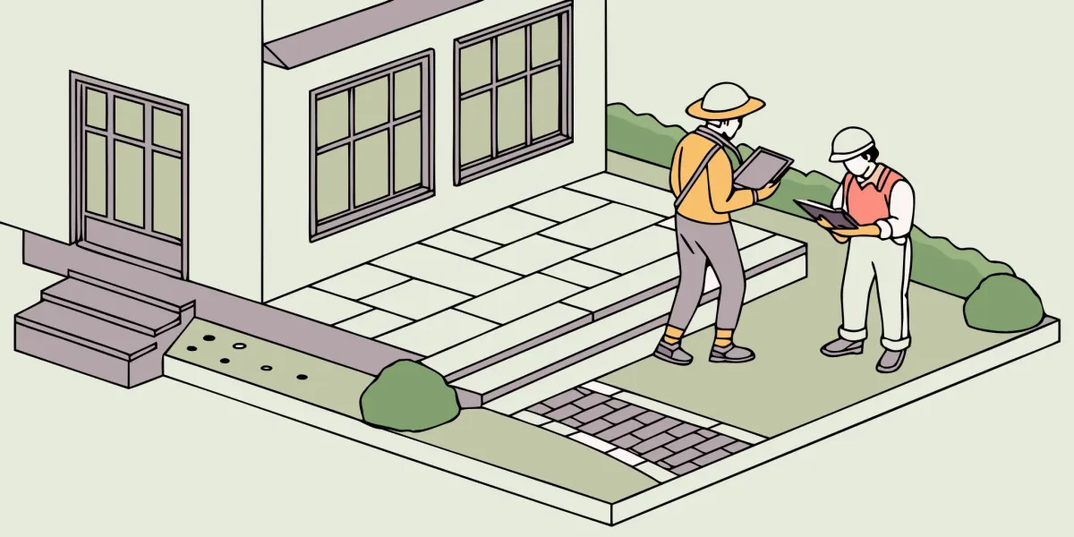 Two professional patio builders reviewing plans for a custom patio installation.