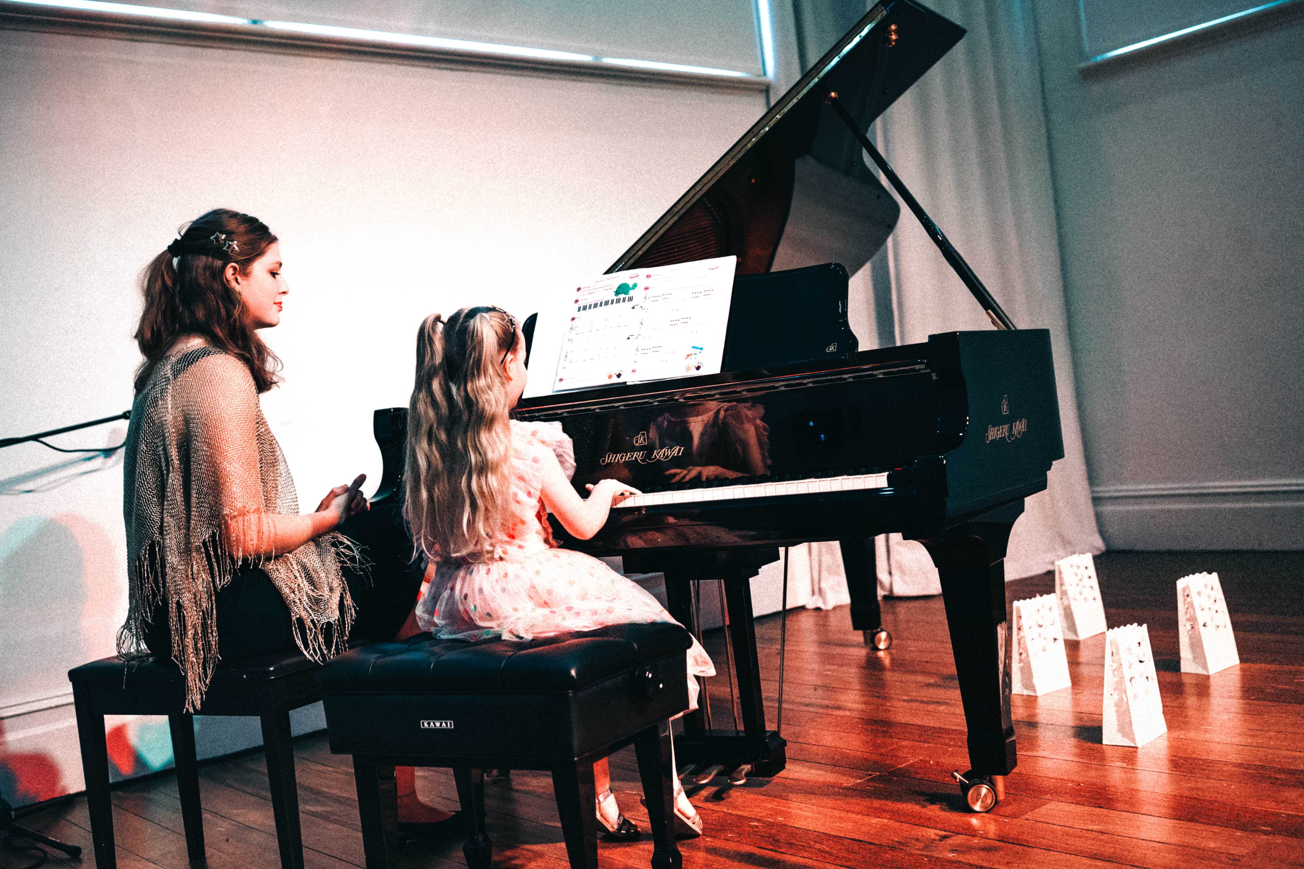 Smiling student at the piano with a friendly teacher at Piano Bug Music Studio