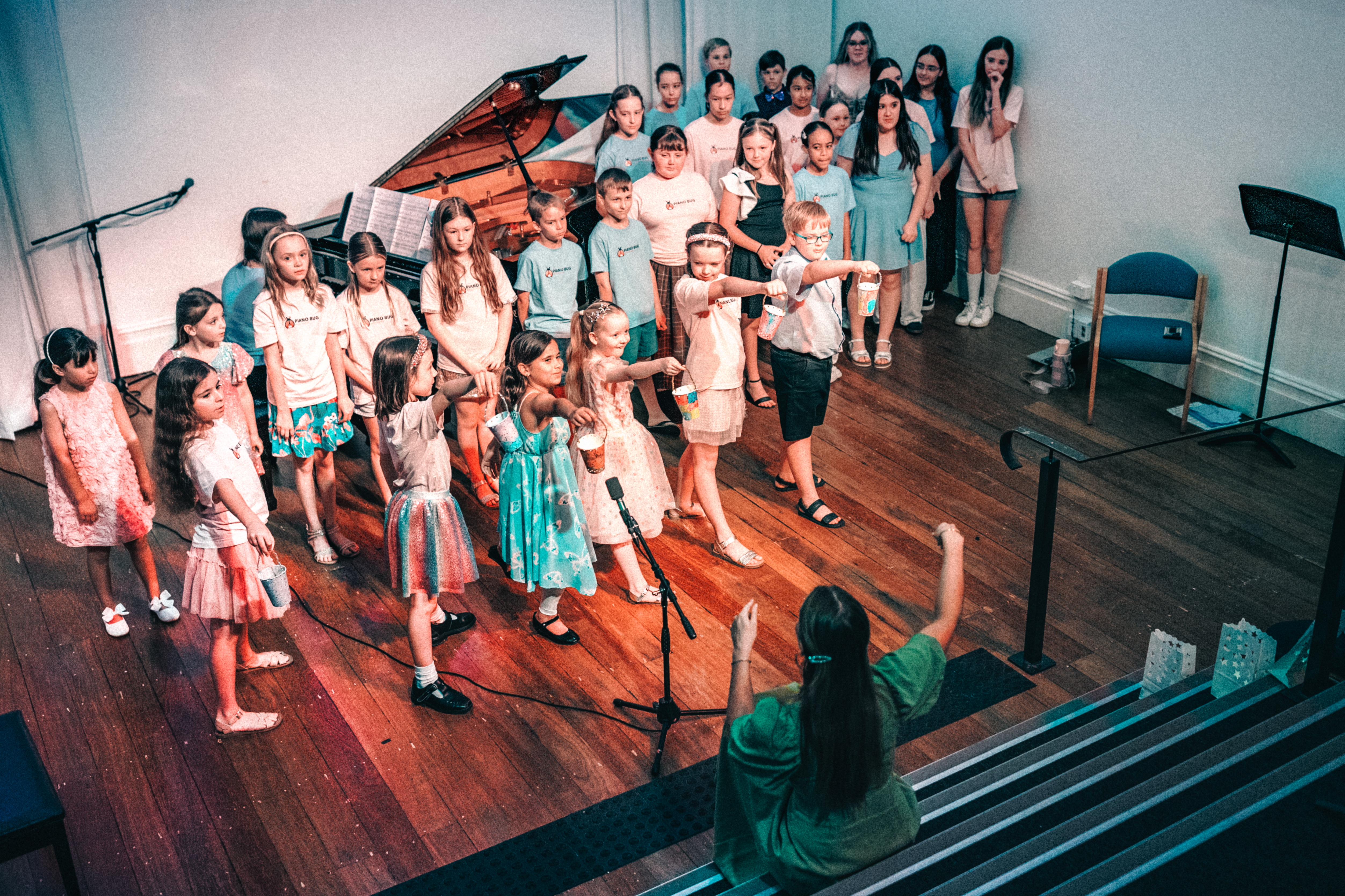 Children singing together in a bright rehearsal space