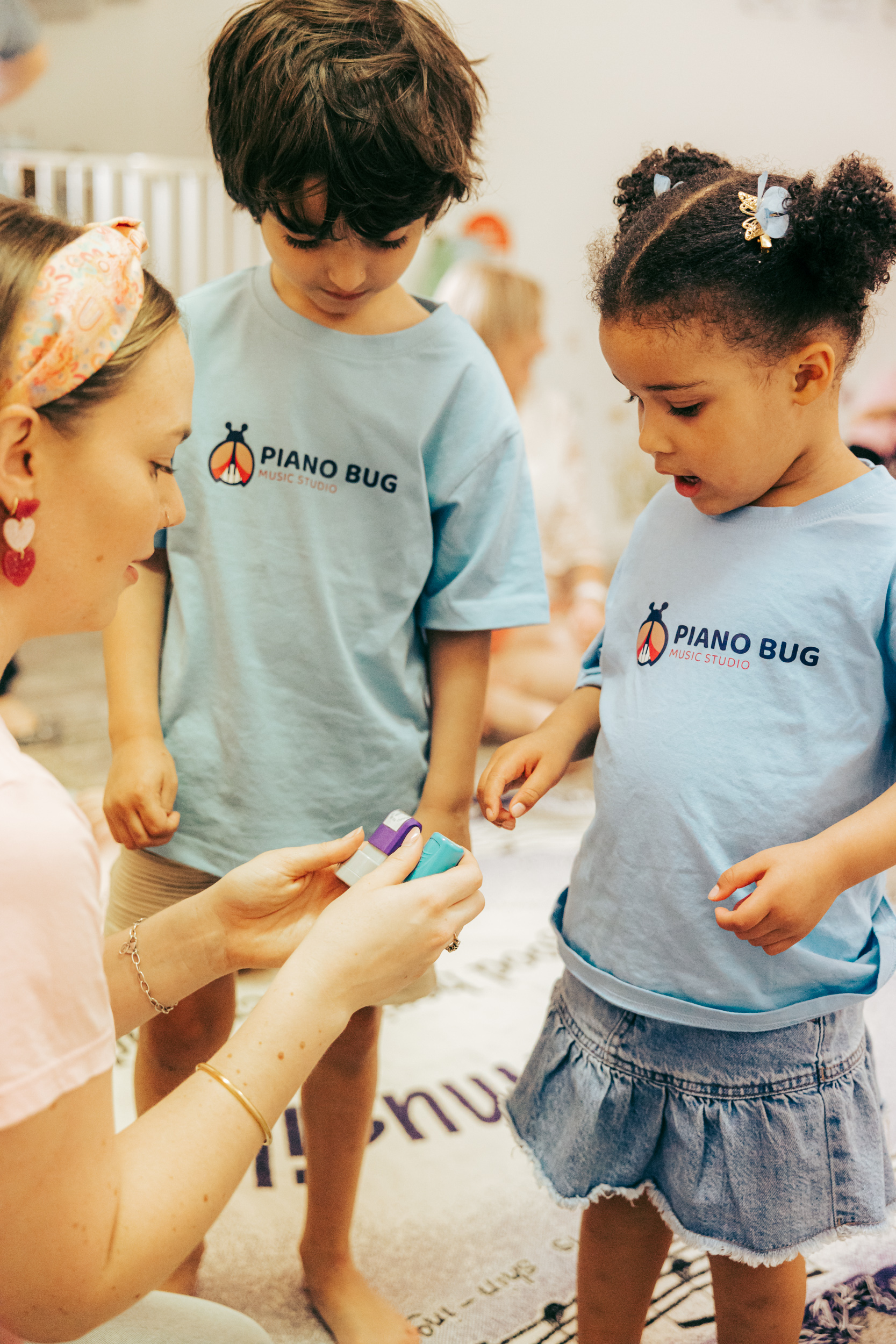 Happy toddlers enjoying a Musikbugs Kindermusik class with instruments and movement
