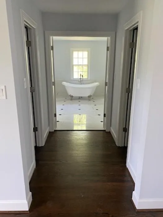 Wooden floor leading to a bathroom