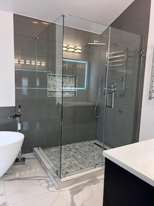 a glass shower with a tub and sink