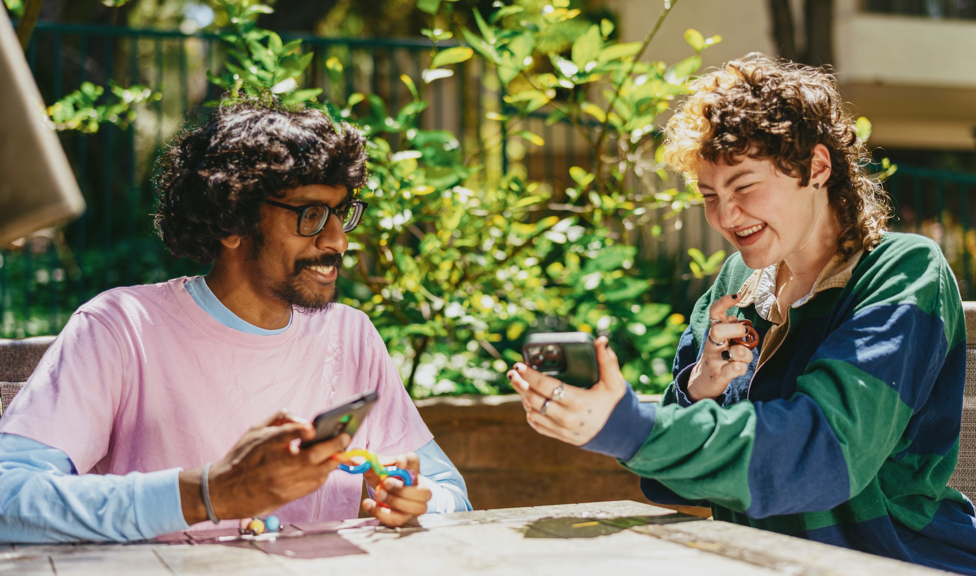 Two people sitting outdoors and sharing a conversation.