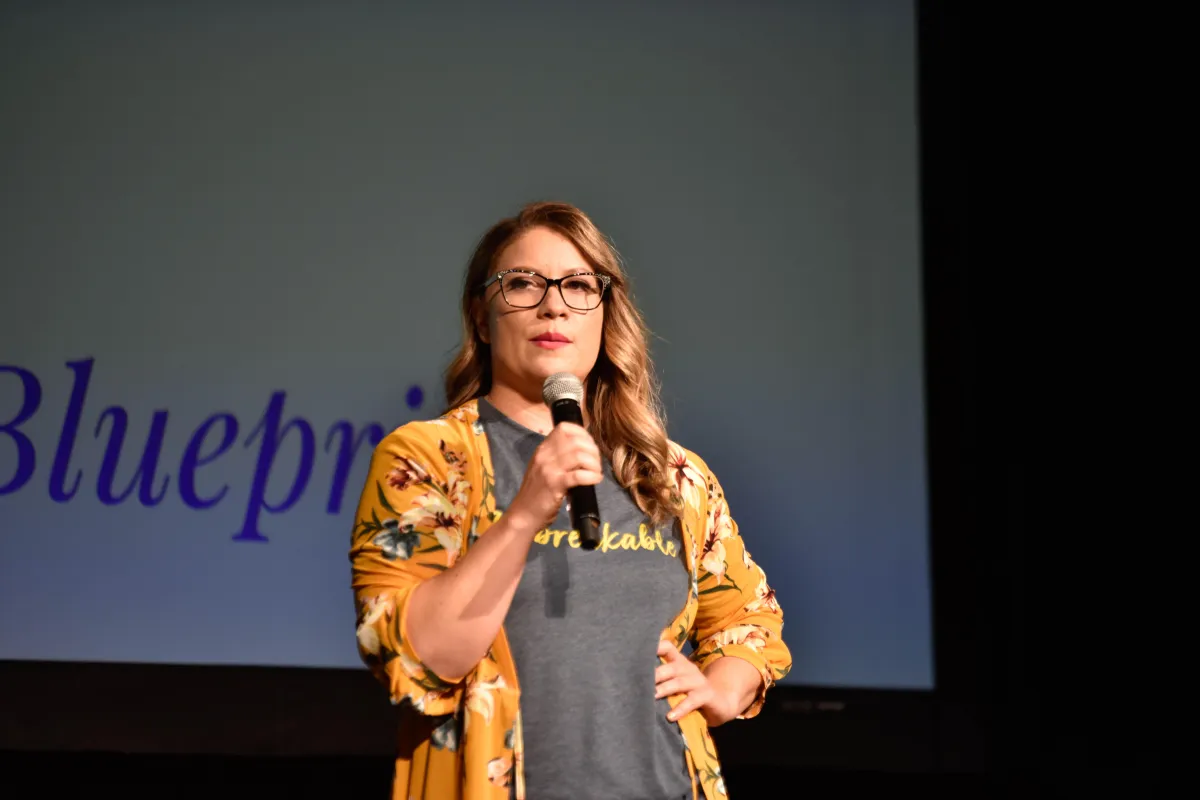 person in red sweater holding babys hand