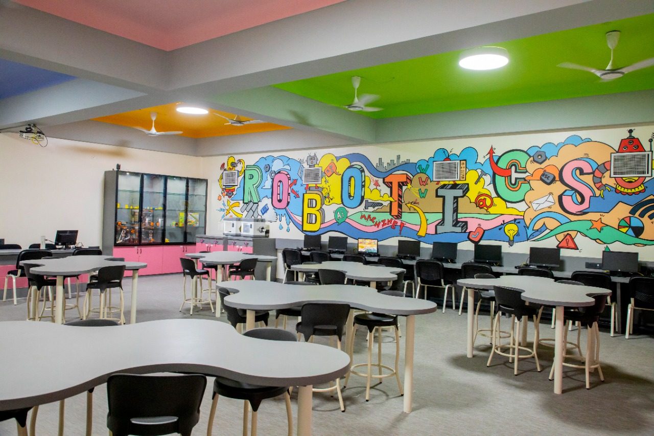 Government school tinkering lab with student workstations and wall mural, funded through a school innovation lab grant