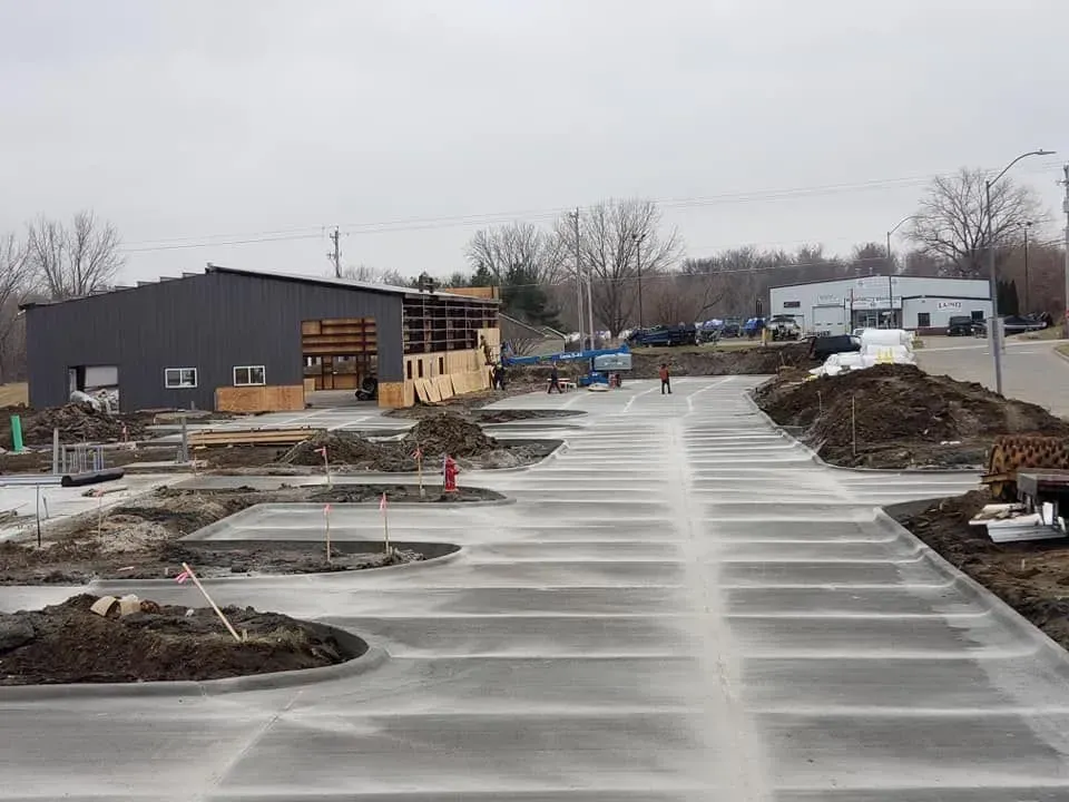 Commercial concrete parking lot pour in progress at new construction site by Quick Concrete Solutions Iowa