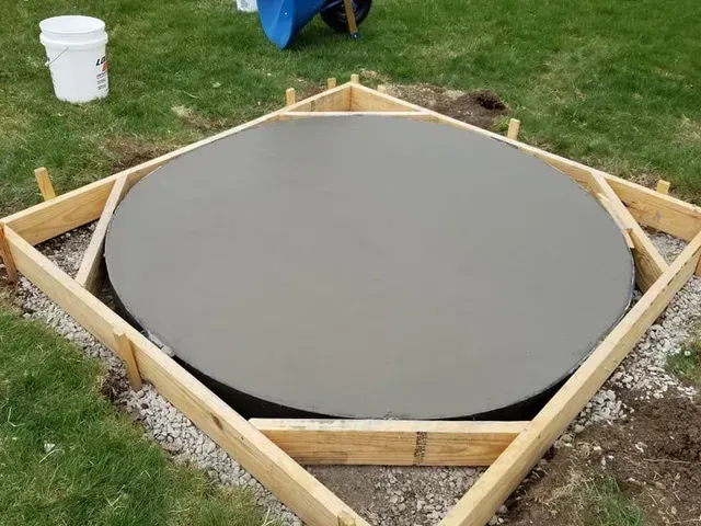 Custom round concrete pad freshly poured in wooden form by Quick Concrete Solutions Central Iowa