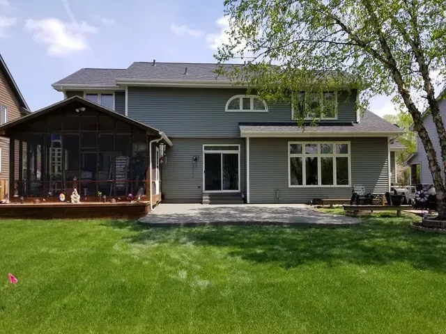 Completed backyard concrete patio installation at two-story home by Quick Concrete Solutions Iowa