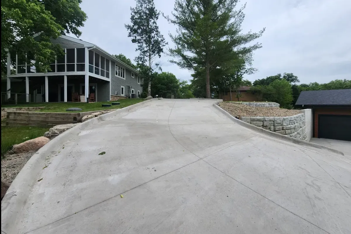 Wide curved concrete driveway at lakefront property by Quick Concrete Solutions Iowa