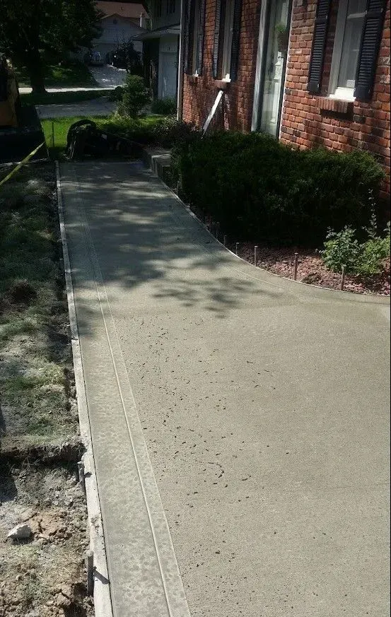 Residential concrete front walkway installation along brick home by Quick Concrete Solutions Central Iowa