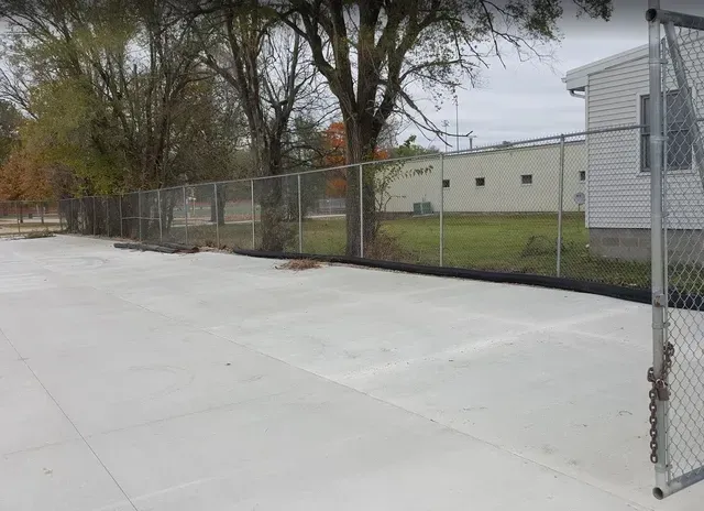 Commercial concrete flatwork slab with chain link fencing by Quick Concrete Solutions Iowa