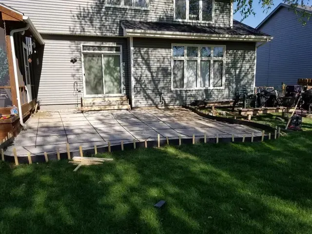 Backyard concrete patio slab freshly poured with forms in place by Quick Concrete Solutions Iowa