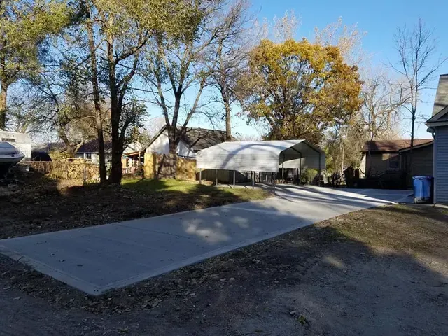 Concrete driveway and parking pad installation at residential property by Quick Concrete Solutions Iowa
