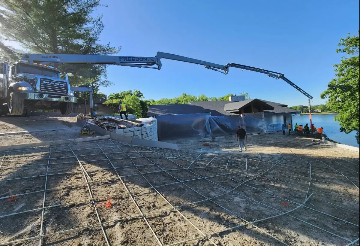 Concrete pump truck pouring large lakefront driveway slab by Quick Concrete Solutions Iowa