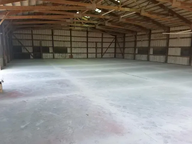 Concrete floor installation inside large agricultural barn by Quick Concrete Solutions Iowa