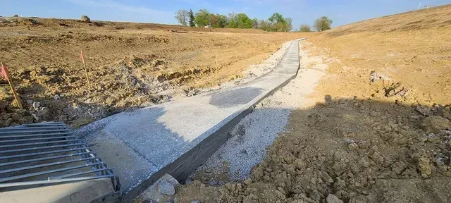 Concrete drainage swale installation on rural development site by Quick Concrete Solutions Iowa