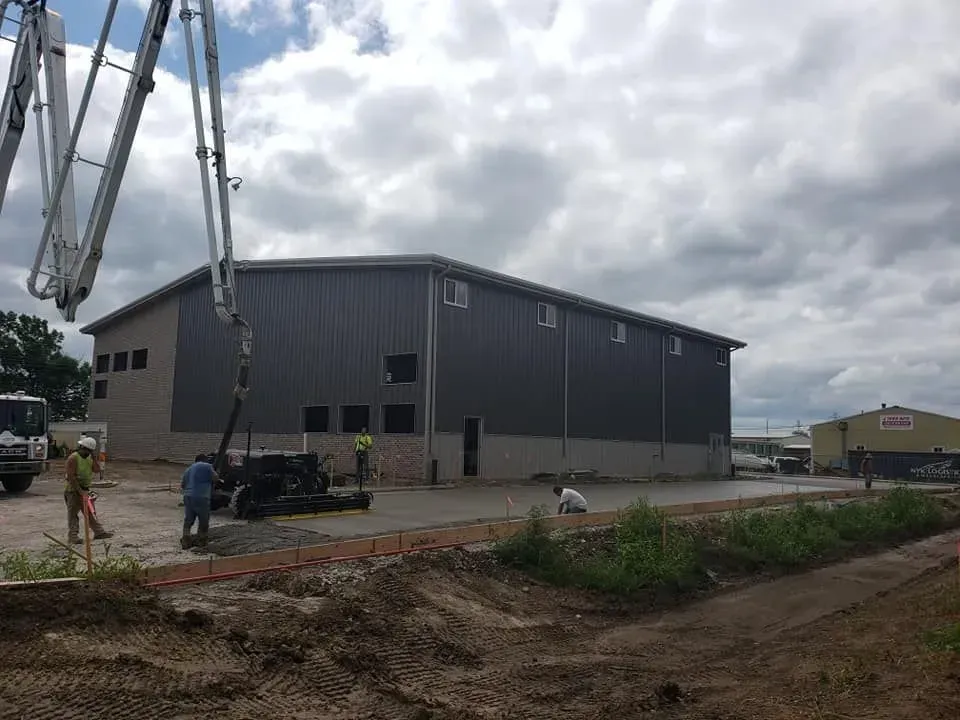 Concrete pump truck pouring commercial warehouse slab by Quick Concrete Solutions Central Iowa