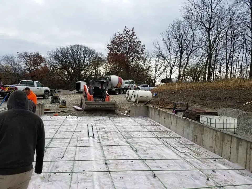 Concrete crew preparing rebar grid with pump truck on site by Quick Concrete Solutions Central Iowa