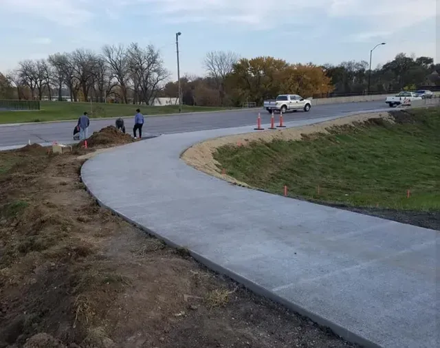 Curved concrete sidewalk installation along public roadway by Quick Concrete Solutions Central Iowa