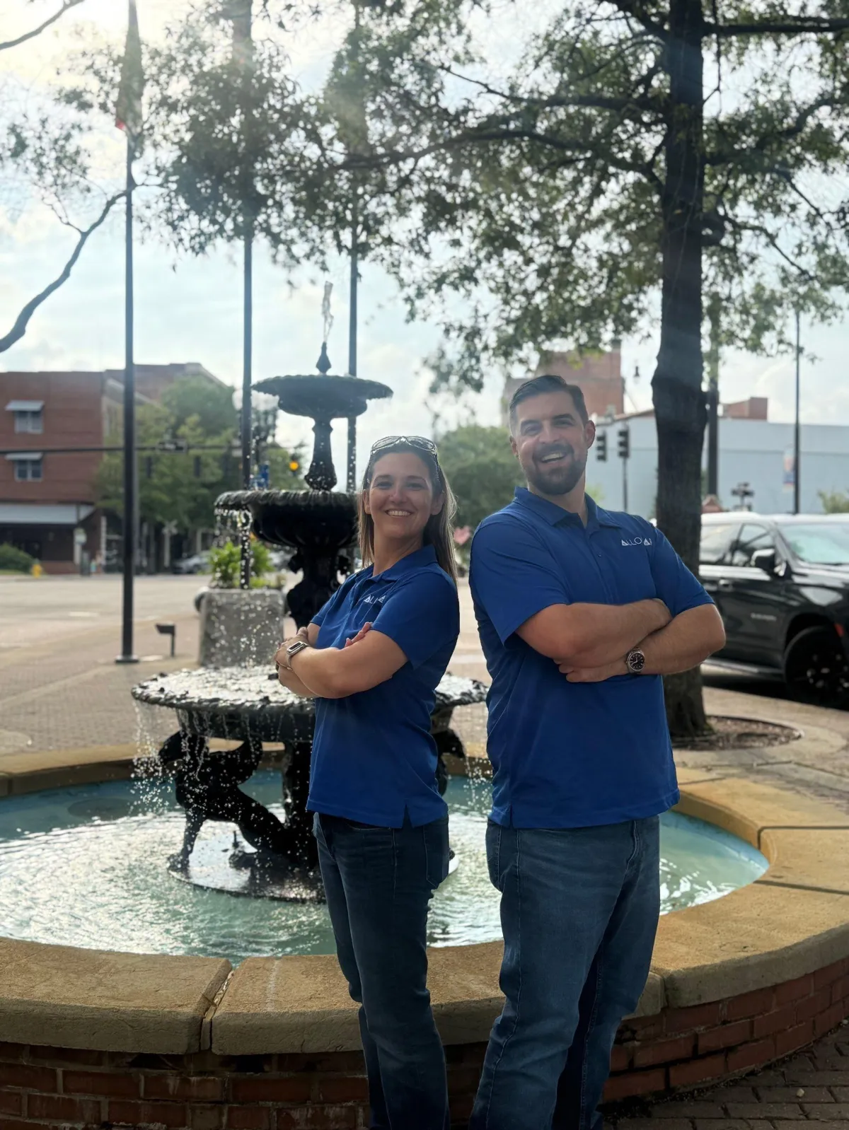 Two professional individuals stand side by side against a white background, featuring the logo for "Allora Homes"