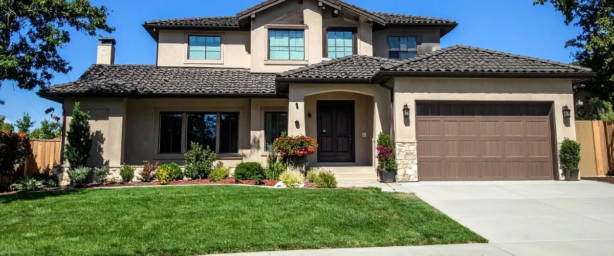 Large modern home with clean exterior and driveway after professional washing