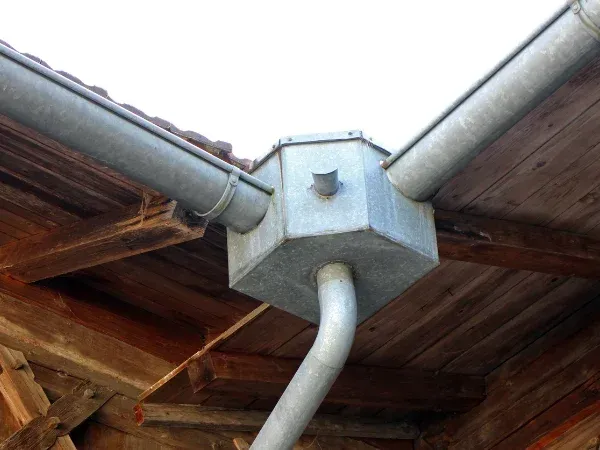 Close-up of metal gutter and downspouts showing roof drainage system