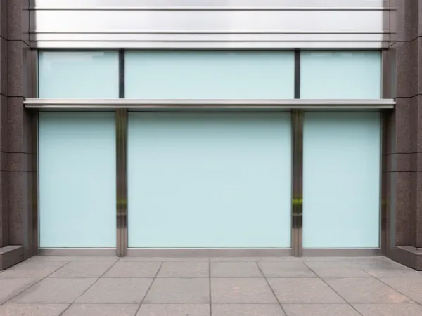 Modern commercial building exterior with clean glass windows and stone facade