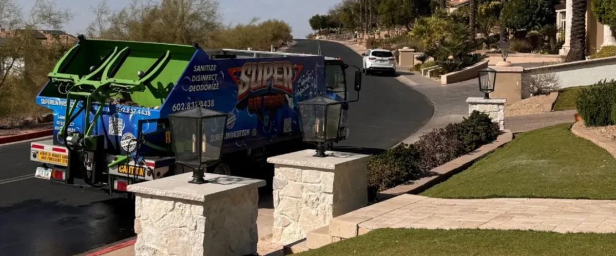 Residential trash bin washing truck providing curbside cleaning service in a neighborhood.