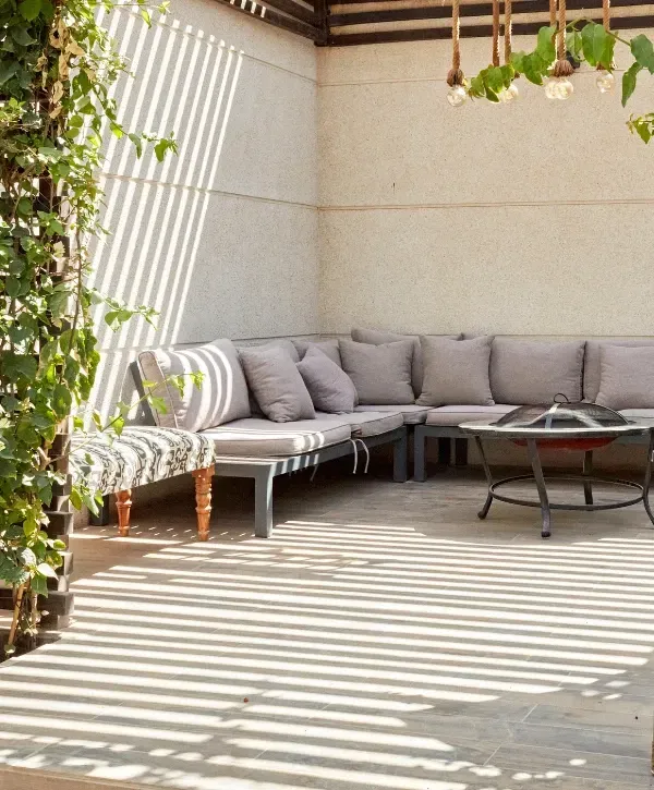 Clean modern outdoor patio seating area with cushions and decorative lighting.