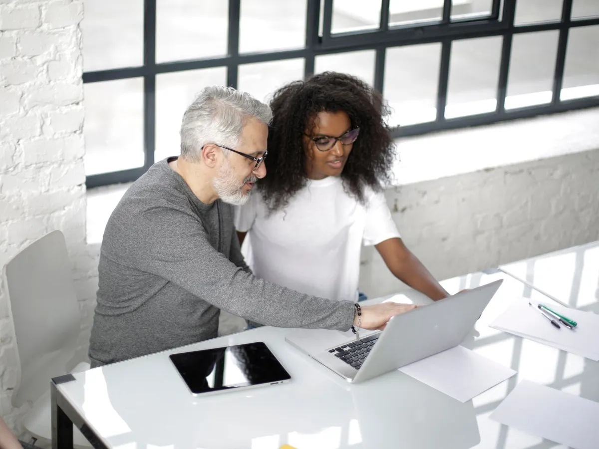 Young founder reviewing her business idea on a laptop with an experienced mentor