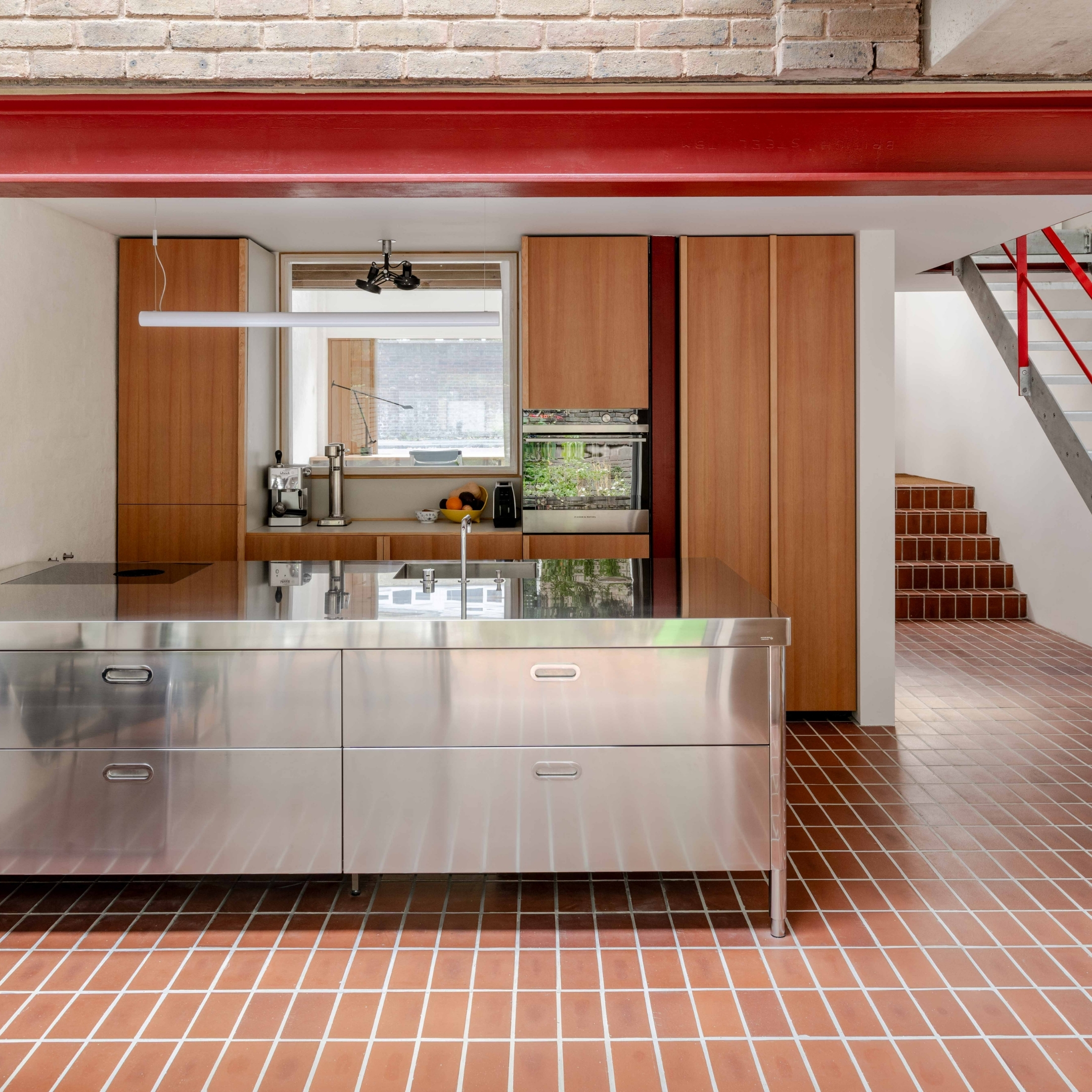 Stainless steel and wood kitchen with red beam and brown clay tiles