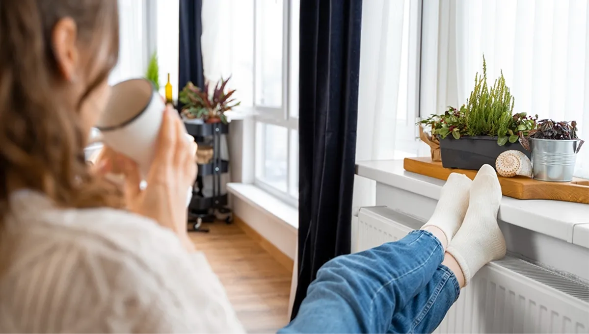 HVAC technician inspects wall-mounted air conditioner in modern living room