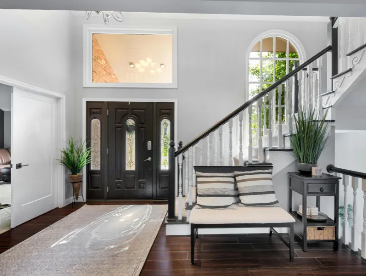 Stylish home entryway remodel with updated staircase flooring and lighting designed and built by professional home remodeling contractors