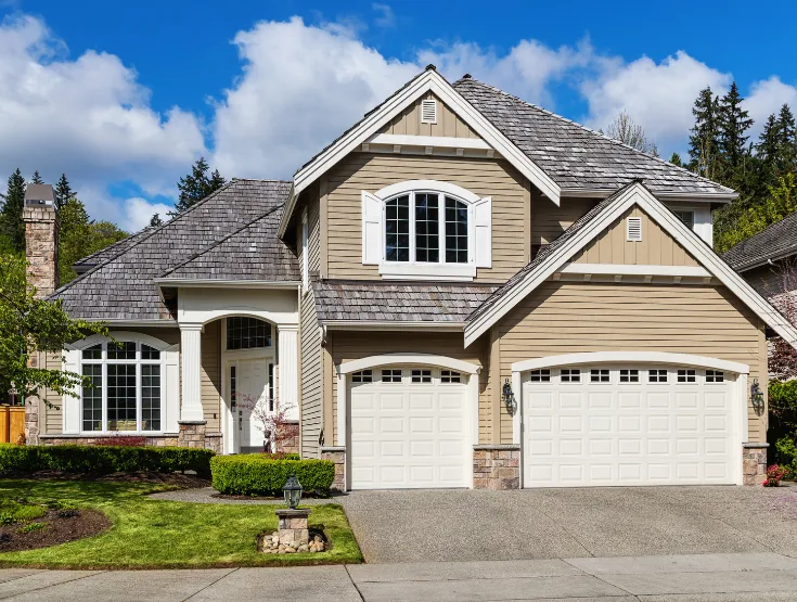 Custom built residential home with attached garage stone accents and landscaped yard constructed by experienced home builders in North Carolina