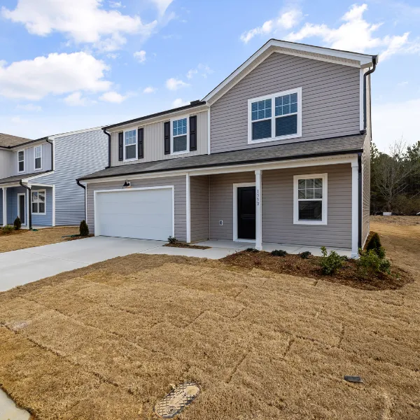 Newly built two story home with attached garage fresh landscaping and durable exterior siding designed for curb appeal and value
