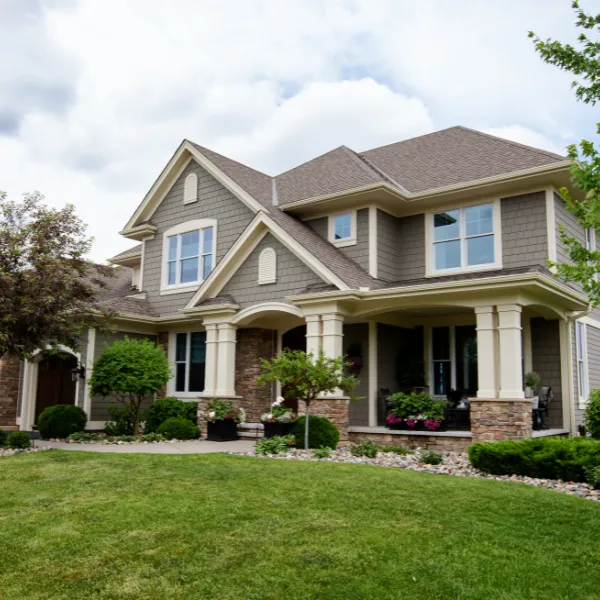 Beautiful two story custom home with front porch manicured lawn and professional landscaping enhancing curb appeal and property value