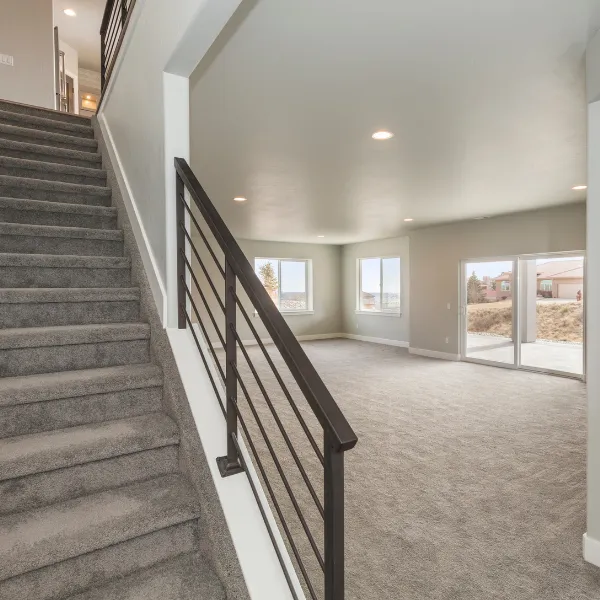 Finished basement with new carpet, recessed lighting, and large windows providing natural light.