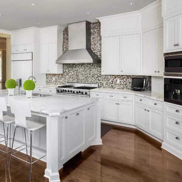 Gourmet kitchen featuring marble countertops, mosaic backsplash, custom cabinetry, and high-end stainless steel range.  