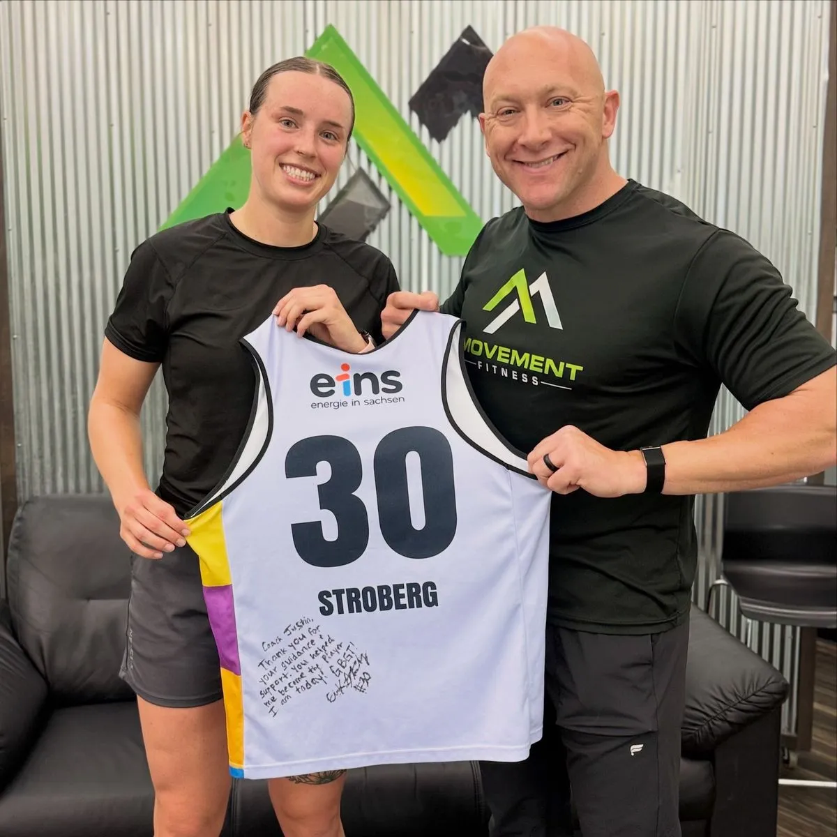 Coach Justin Kegley and Erin Stroberg holding her signed professional jersey