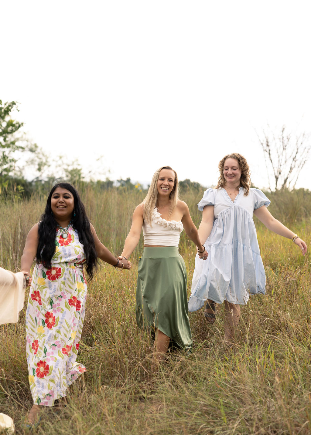 Two female participants of Level Up Club laughing and holding hands outside 