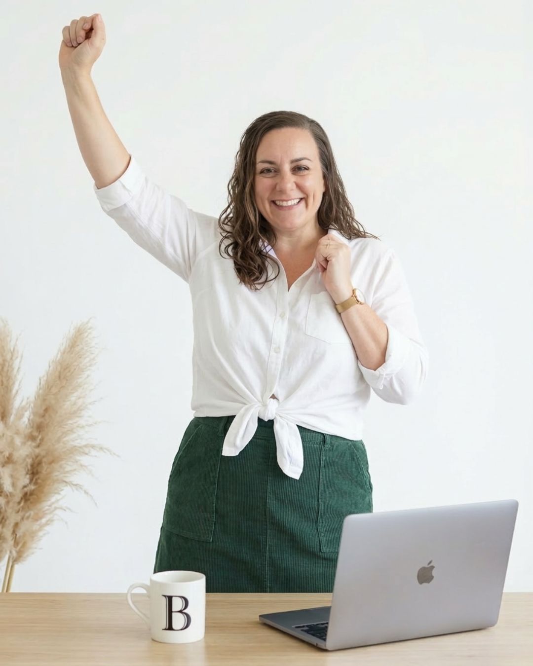 Brenda of Informed Tech Solutions celebrating at her desk with a laptop, helping female attorneys automate law firm workflows