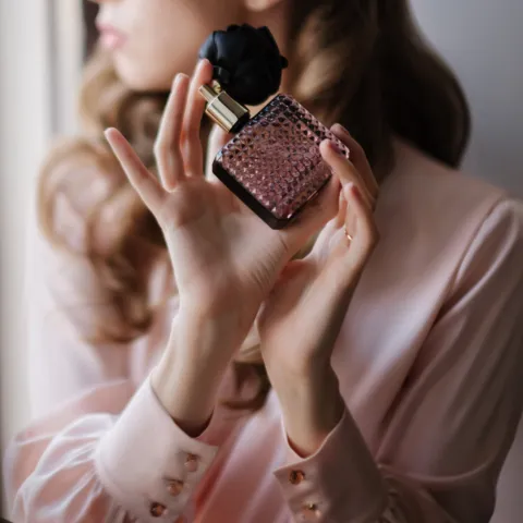 Woman turns away from perfumes and cleaners — illustrates scent sensitivity and environmental triggers