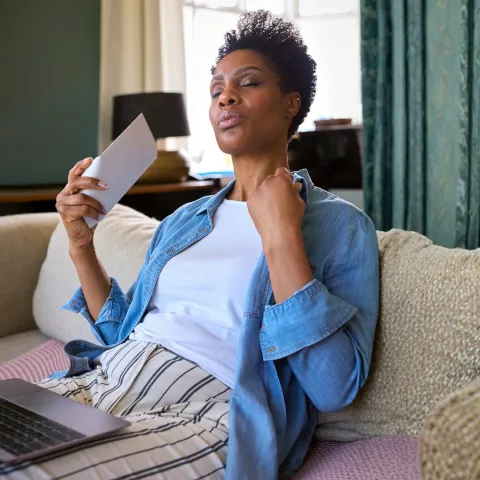 Woman dealing with a hot flash representing hormonal signals, hormonal balance, and natural hormone support.