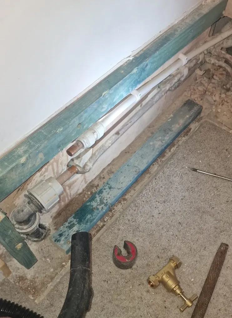 Emergency plumber repairing a burst copper water mains pipe and fitting a new isolation stopcock in Plymouth