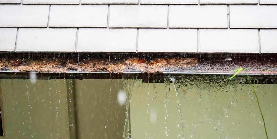 Clogged gutters that are overflowing with water