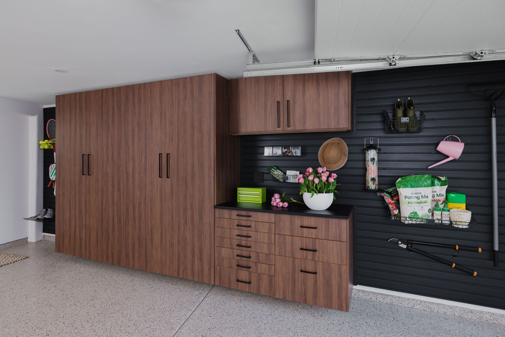 Sleek wood finish garage closets configured for clean hidden residential organization