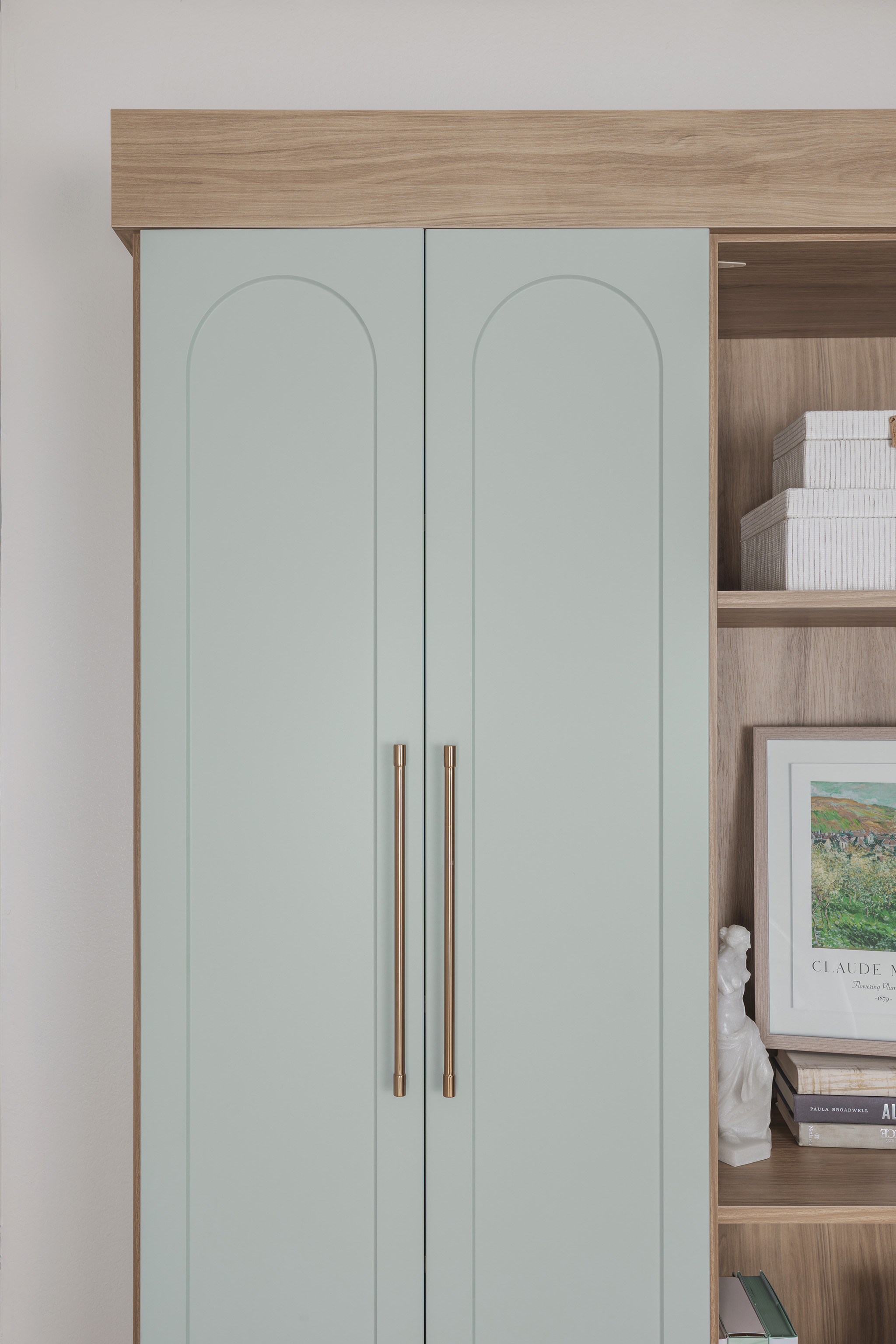 Luxury custom bookshelves near me showcasing matte nickel hardware and soft green shaker doors